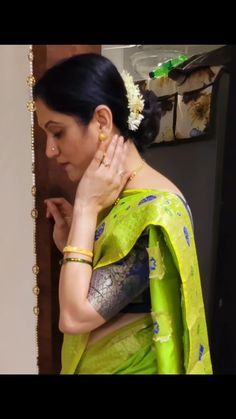 a woman in a green sari is holding her hands on her chest and looking down