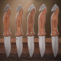 five knives with wooden handles are lined up in a row on a table, one is open and the other has an engraved name