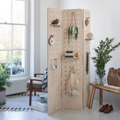 a room that has some plants on the wall and bags hanging up against the wall