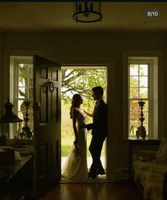 a bride and groom are standing in the doorway