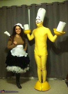 two women dressed in costumes standing next to each other with mugs on their hands