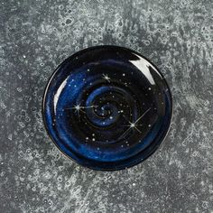 a black and blue bowl with stars on the top is sitting on a gray surface