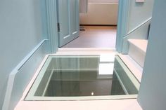 an empty room with a glass floor in the middle