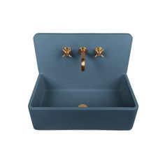 a blue sink with two golden faucets on it