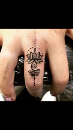 a person's hand with a tattoo on it and a flower in the middle