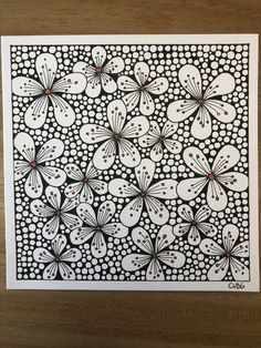 a black and white drawing on wood with dots in the middle, surrounded by smaller circles