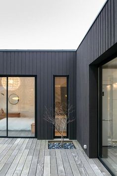 a wooden deck with glass doors leading to a bedroom