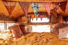 a bed in a small room with lots of pillows and blankets on top of it