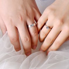 two people holding hands with wedding rings on top of each other's fingers and wearing tulle skirts