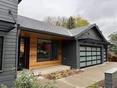 a gray house with wood trim and windows