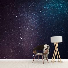 a chair and lamp in front of a wall with stars on the night sky behind it