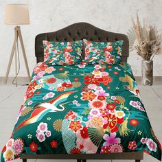 a bed covered in a green floral comforter next to a lamp