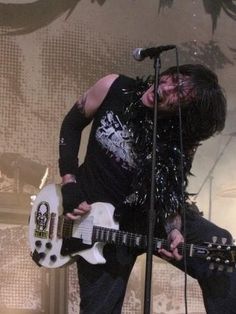 a man in black shirt playing guitar on stage