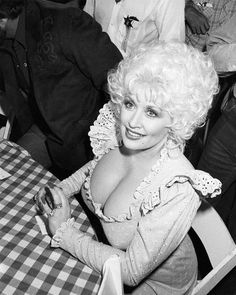 a woman sitting at a table smiling for the camera