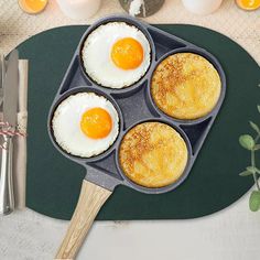 three fried eggs in a muffin pan with a wooden spatula on the side