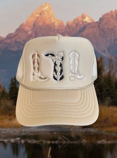 Tan trucker hat with 3 embroidered cowboy boots in the perfect neural fall colors One size fits most due to adjustable snap closure. Breathable mesh back.