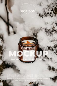 a candle is sitting in the snow next to some trees and branches with text that reads candle mockup photoshop maker