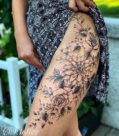 a woman's thigh with flowers on it and her leg in the foreground