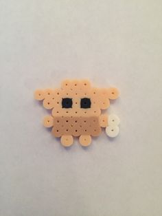 a close up of a small animal made out of plastic beads on a white surface