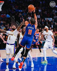 the basketball players are trying to block the ball from going into the basket in front of them