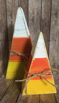 two small wooden triangles with twine tied to each other on a wood surface