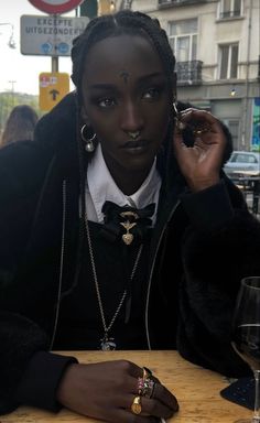 a woman sitting at a table with a glass of wine in front of her face