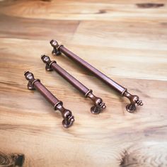 three antique style handles on a wooden table