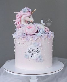 there is a cake decorated with flowers and a unicorn on top