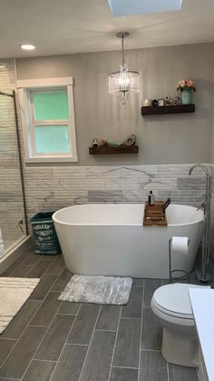 a white bath tub sitting in a bathroom next to a toilet