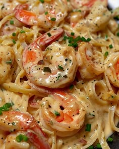 pasta with shrimp and sauce on it sitting on a plate