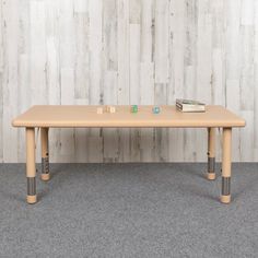 a wooden table sitting on top of a carpeted floor next to a white wall