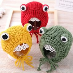 three knitted hats with googly eyes and an octopus on the front, one in red, one in green