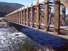 a wooden bridge over a river with water running underneath it