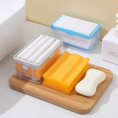 two plastic containers with soap and cheese on a wooden cutting board