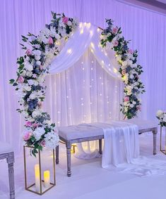 a wedding ceremony setup with white and pink flowers on the altar, candles and drapes