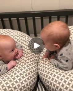 two babies are playing with each other in their cribs and they look like they're talking to each other