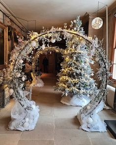 an archway decorated with christmas trees and snowflakes in a room filled with windows