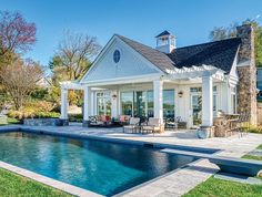 a house with a pool in front of it and an outdoor dining area next to the pool