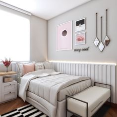 a bedroom with white walls and pictures on the wall above the bed, along with a black and white striped rug