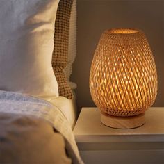 a wicker lamp sitting on top of a night stand