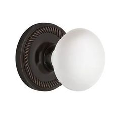 an antique style door knob with a white glass ball on the front and black trim