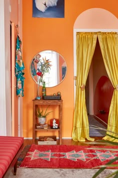 a living room with orange walls and yellow curtains