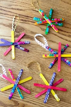 four popsicle crafts are arranged in the shape of snowflakes on a wooden table