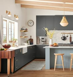 a kitchen with grey cabinets and wooden stools