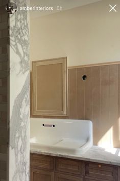 an empty bathroom with marble counter tops and wooden cabinetry in the backround