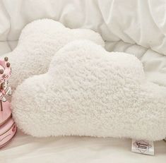 a pair of pink boots sitting on top of a white bed next to a pillow