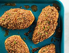 three pieces of breaded chicken on a blue tray with green onions and seasoning