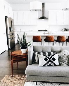 a living room filled with furniture next to a kitchen