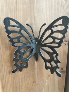 a metal butterfly mounted to the side of a wooden door