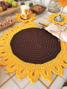 a crocheted placemat sits on a table next to other food and drinks